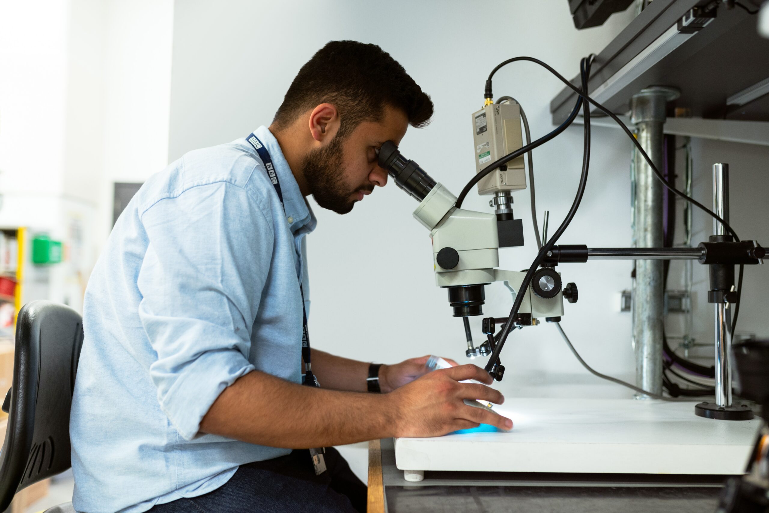 Researcher using a microscope in a laboratory setting, representing a Treasurer role supporting financial governance for a charity focused on research, knowledge and development across the Global South.