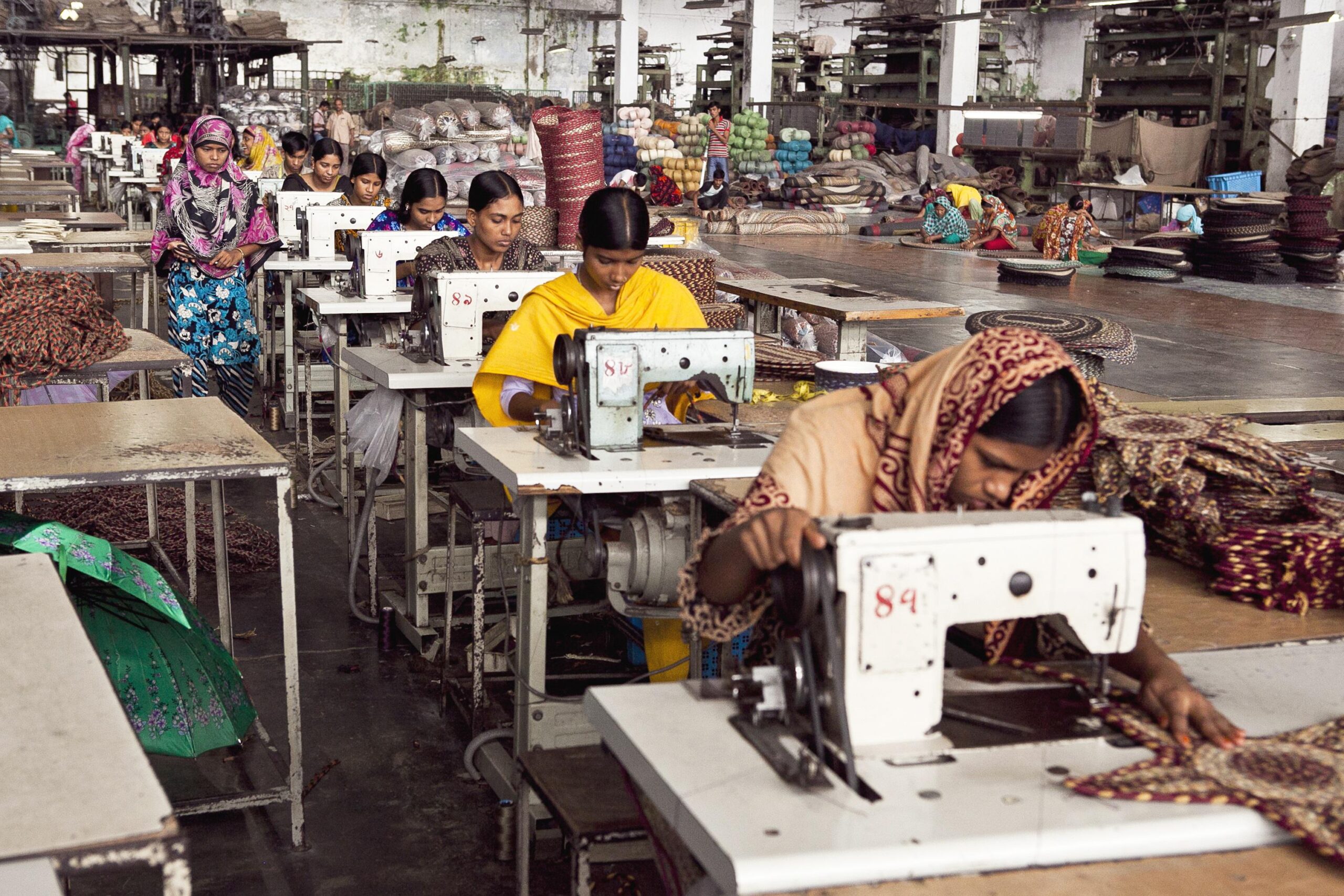 Women working at sewing machines in a garment factory, representing workplace programmes and support for women workers in global supply chains.